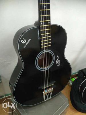 Full black acoustic guitar, with hollow body and