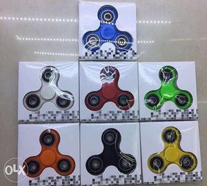 Seven Yellow, Blue, And Green Fidget Hand Spinners In Box