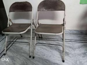 Two White Metal Framed Gray Padded Folding Chairs