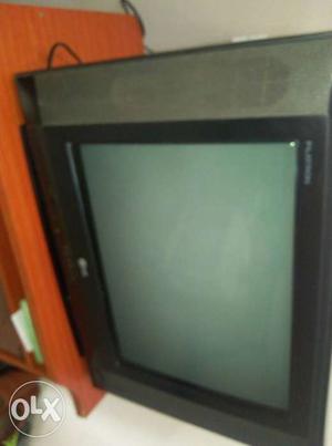Black And Gray LG Widescreen CRT TV On Brown Wooden Stand
