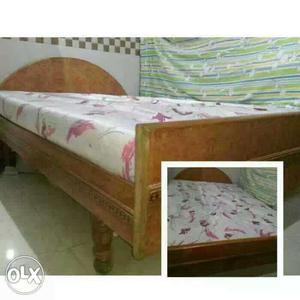 Brown Wooden Bed Frame And White Bed Shee