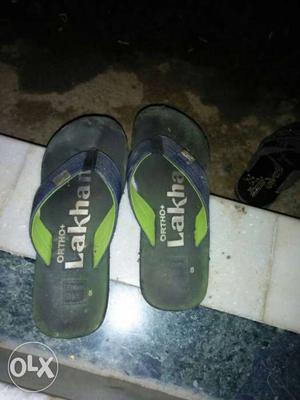Pair Of Black Green White And Blue Flip Flops