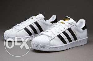 Pair Of White And Black Adidas Sneakers