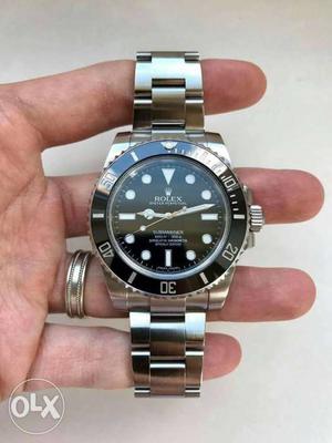 Rolex round steel black dial watch.