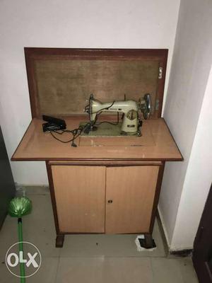 Electric motor sewing machine and inverter battery stand
