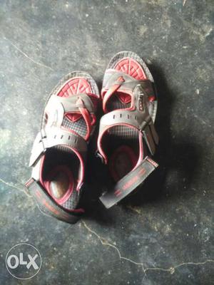 Pair Of Gray And Red Velcro Strap Sandals