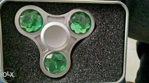 Gray Fidget Spinner With Green Gemstone In Case