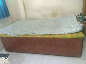Brown queen sized bed with storage