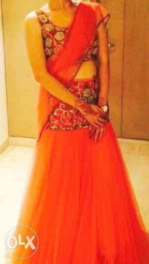 Orange net lehnga with gold floral embroidery,