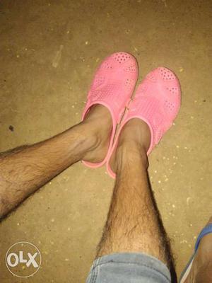Person's Pair Of Pink Rubber Clogs