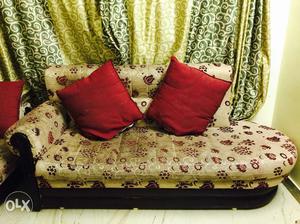 Brown And Red Floral Sofa With Two Red Throw Pillows