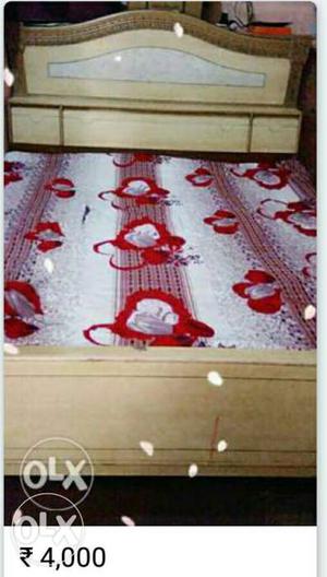 Red Floral Bed Linen And Beige Wooden Bed Frame
