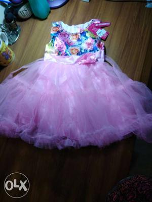 Baby frock, brand-new. Pink skirt with blue roses