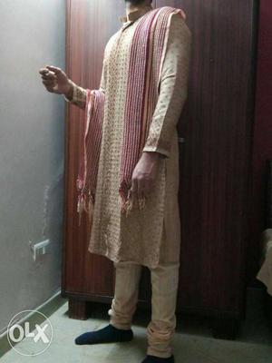 All over embroidered sherwani with maroon work.