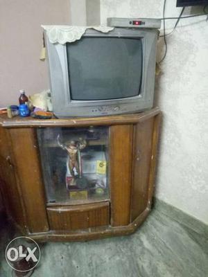 Gray CRT TV; Brown Wooden TV Stand