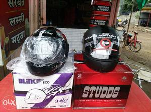 Two Black Crash Helmets With Boxes
