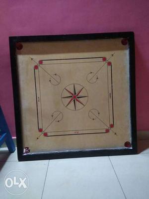Carrom board with coins and striker