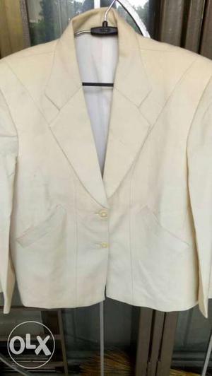 Cream color waist length coat.