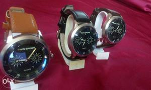 Three Black Round Faced Chronograph Watches With Brown