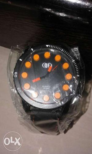 Round black and orange chronograph watch with