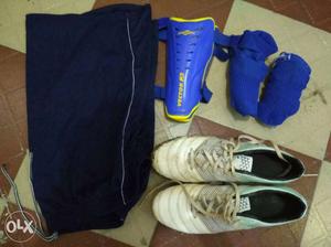White Cleats, Blue Socks, Blue Shin Guard, And Black Shorts