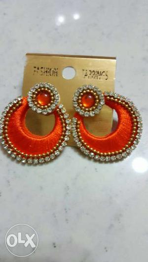 Pair Of Orange Embellish Diamonds Jhumka Earrings
