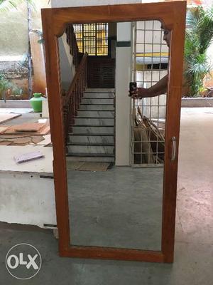 Mirror enclosed with a teak wood frame on all the sides