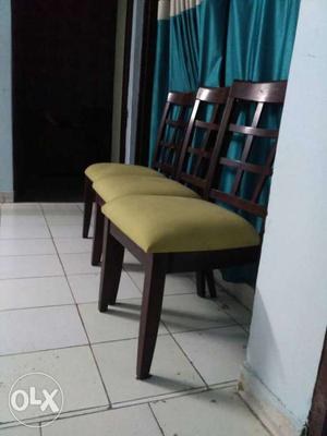 Three Beige Pad With Brown Wooden Base Armless Chairs