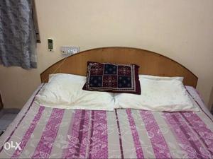 Wooden double bed with storage available inside.