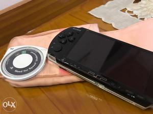 Psp With A Game Cd Cover And Charger