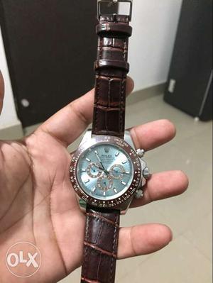 Round Silver Rolex Chronograph Watch With Brown Leather