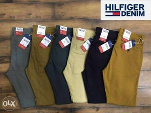 Six Pairs Of Brown, Gray, And Black Hilfiger Denim Bottoms