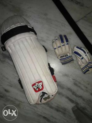 A pair of white Cricket gloves n A pair of cricket pads