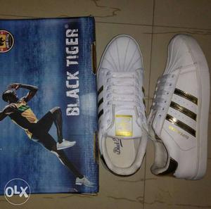 White-and-gold Adidas Superstar