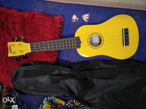 Brand new yellow ukulele + two picks + a bag