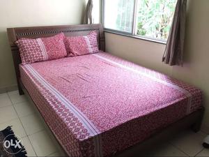 Brown Wooden Framed Bed With Pink Floral Bedspread