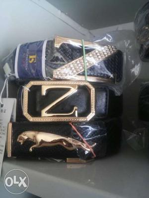 Three Gold Buckles With Black Leather Belts