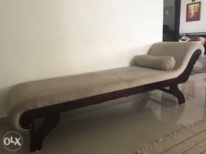 Handcrafted solid wood diwan has a roller pillow along with