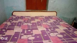 Pink And Beige Bed Sheet And Brown Wooden Headboard