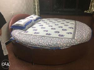Round Brown Bed Frame With White And Blue Bedspread