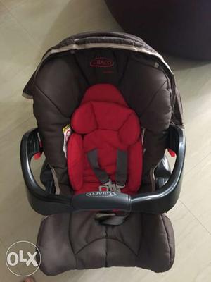 Baby's Red And Brown Car Seat Carrier from Graco