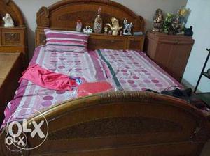 Brown Wooden Bed With Pink-white-and-purple Bed Spread Sheet