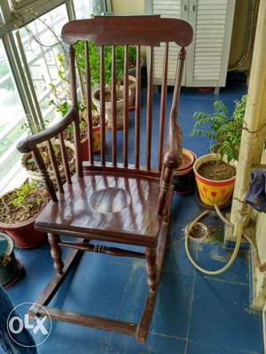 A teak wood rocking chair, relatively unused, in