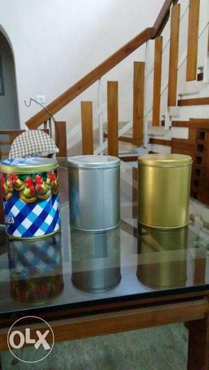 Three Yellow, Grey, And Blue Printed Metal Canisters
