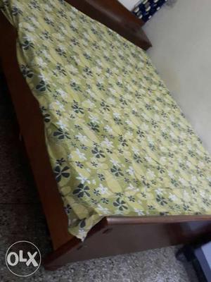 Brown Wooden Bed Frame With Green And White Floral Beddings
