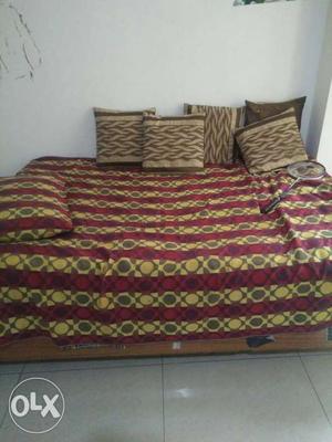 Brown Wooden Bed Frame With Yellow And Red Bedspread