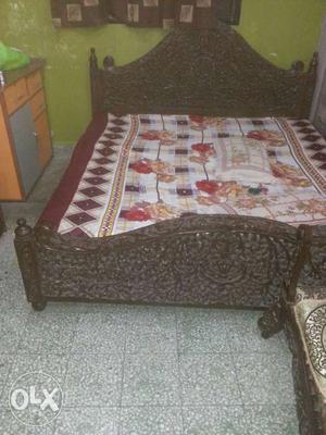Gray Wooden Bed With Multi Colored Bed Sheet