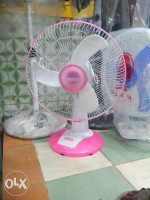 Two White, Pink, And Blue Desk Fans