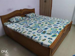 Brown Wooden Bed Frame With White Bed Sheet