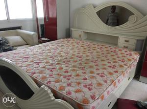 Cot and mattress, dining table, chair, TV stand.